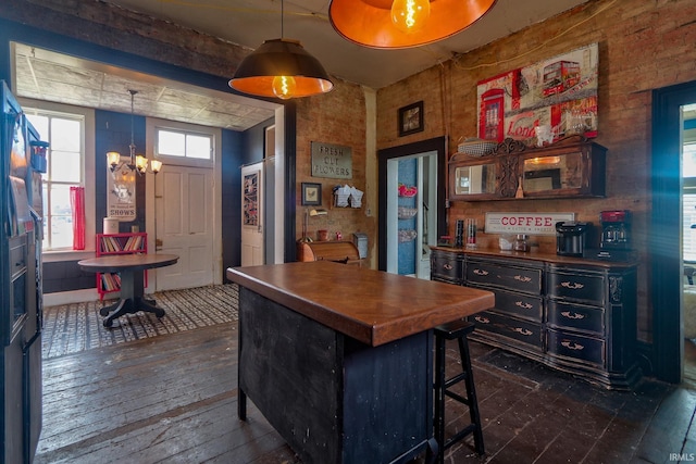 kitchen featuring hanging light fixtures, a breakfast bar area, a chandelier, and dark wood-type flooring