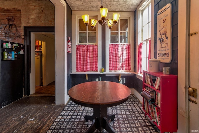 dining area with a chandelier and dark wood-type flooring