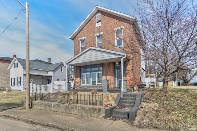 view of front of house featuring a fenced front yard and brick siding