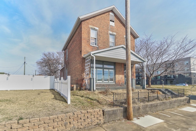 view of front facade with a fenced front yard and brick siding