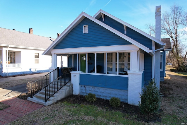 bungalow-style house with a porch and brick siding