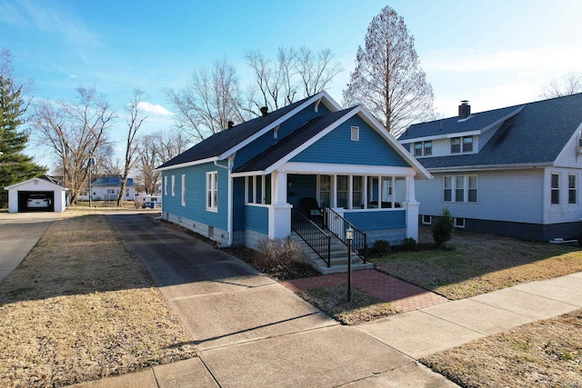 bungalow featuring a garage, an outbuilding, covered porch, and driveway