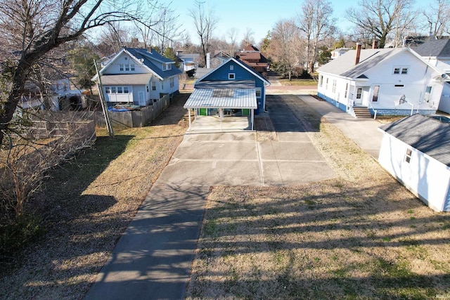 exterior space with an outbuilding, driveway, fence, and a residential view