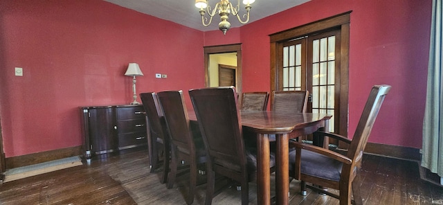 dining room featuring french doors, dark wood finished floors, baseboards, and an inviting chandelier