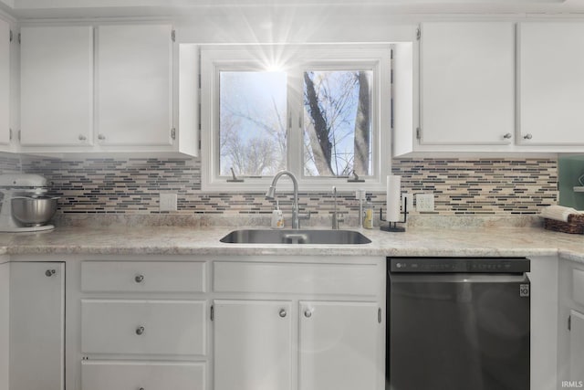 kitchen with light countertops, white cabinetry, dishwasher, and a sink