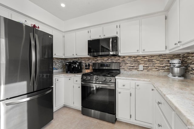 kitchen featuring backsplash, white cabinetry, stainless steel appliances, and light countertops