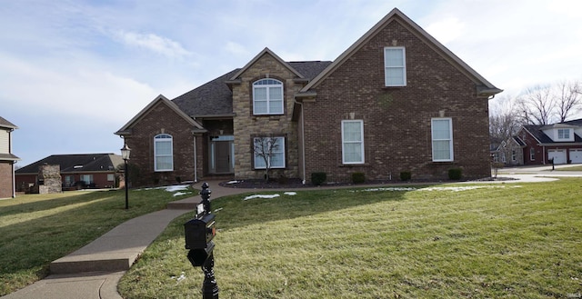 traditional home with a front yard, stone siding, and brick siding