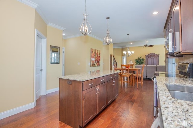 kitchen featuring ornamental molding, dark wood-type flooring, pendant lighting, and baseboards