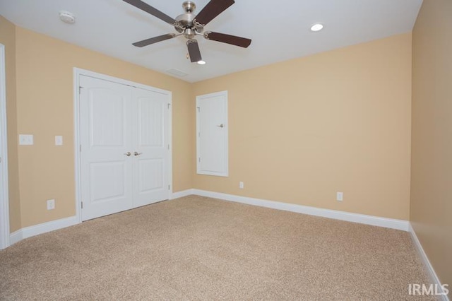 unfurnished bedroom with recessed lighting, baseboards, a closet, and light colored carpet