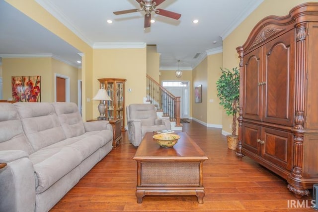 living area featuring baseboards, ornamental molding, stairs, light wood-type flooring, and recessed lighting