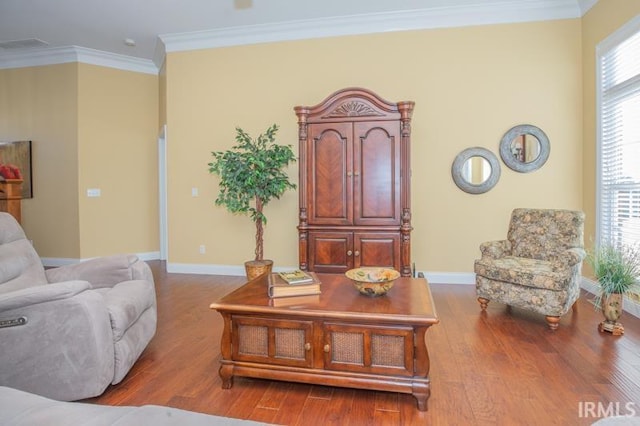 living area with baseboards, wood finished floors, and crown molding