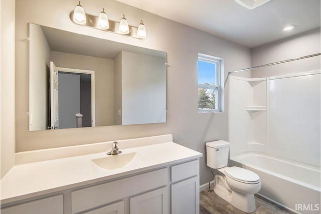 bathroom featuring wood finished floors, shower / tub combination, vanity, and toilet