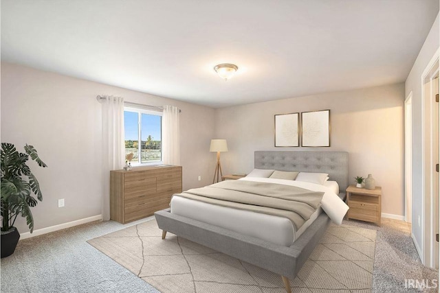 bedroom with light colored carpet and baseboards