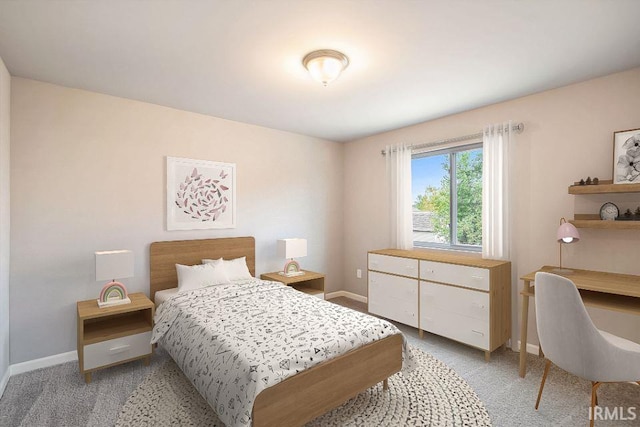 bedroom with light colored carpet and baseboards