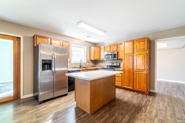 kitchen with stainless steel appliances, a sink, light countertops, a center island, and dark wood finished floors