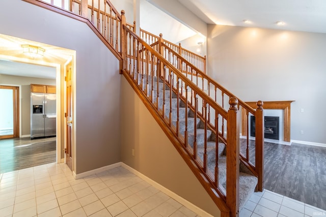 stairs featuring high vaulted ceiling, beamed ceiling, tile patterned flooring, and baseboards