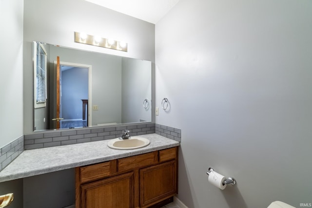 half bath with toilet, tasteful backsplash, and vanity