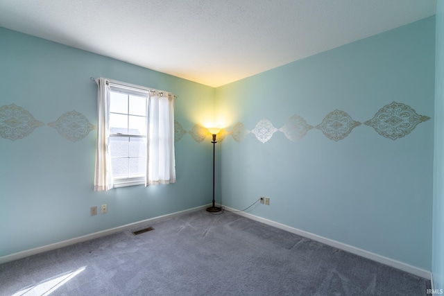 carpeted empty room with visible vents and baseboards