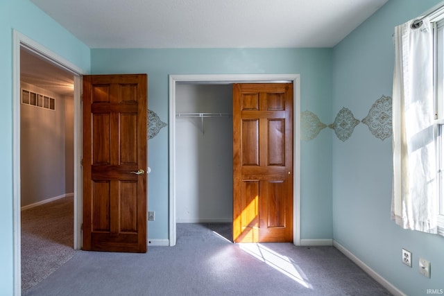 unfurnished bedroom featuring light carpet, multiple windows, a closet, and visible vents