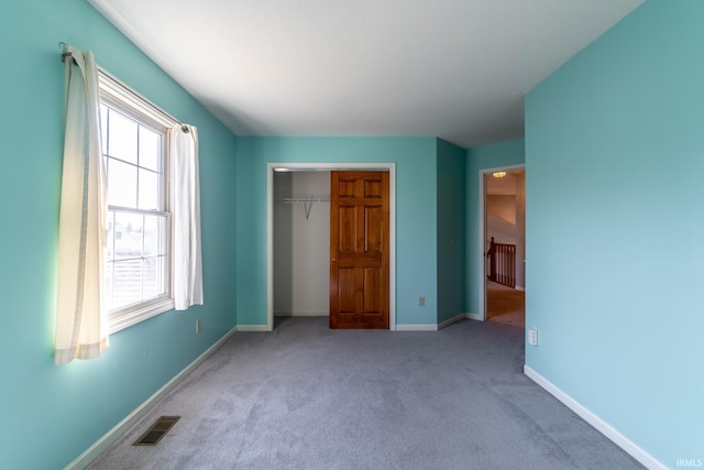 unfurnished bedroom featuring light carpet, baseboards, visible vents, and a closet