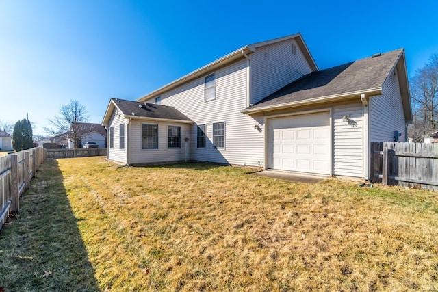 back of property featuring a garage, fence, and a lawn