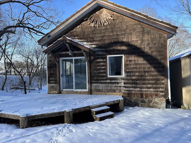 snow covered rear of property featuring a wooden deck