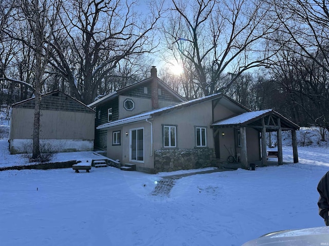 view of front of house featuring a chimney and stucco siding