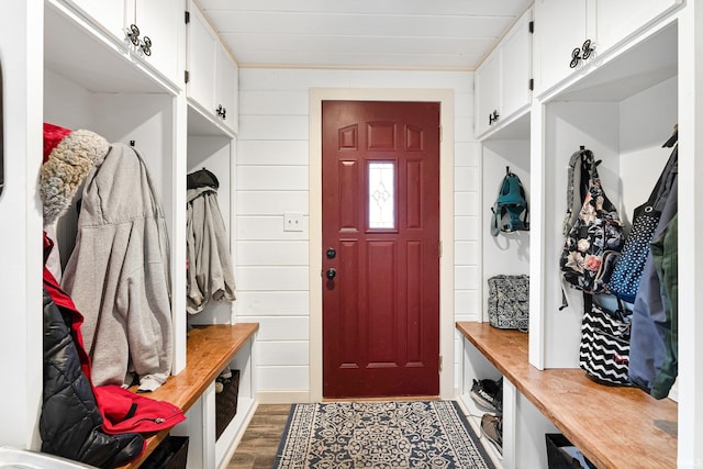 mudroom featuring dark wood finished floors and wood walls