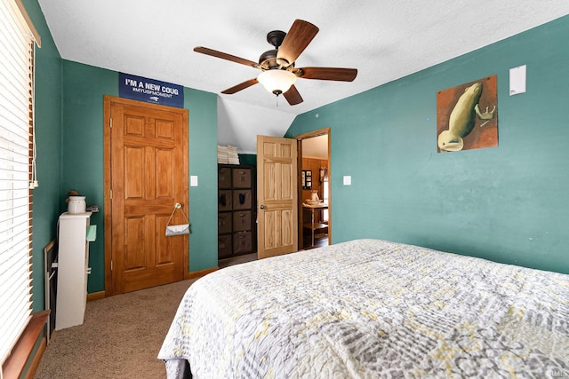 bedroom with vaulted ceiling, ceiling fan, a textured ceiling, and carpet flooring