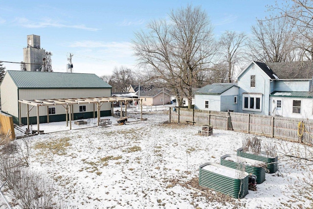 yard covered in snow with fence, a residential view, and a pergola