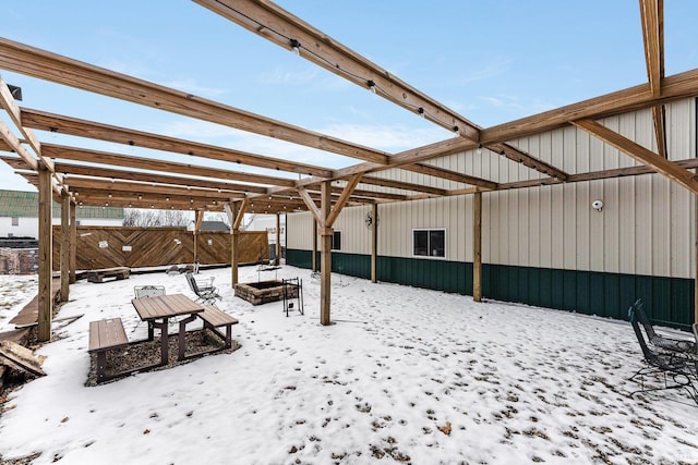 snowy yard featuring a fire pit and fence