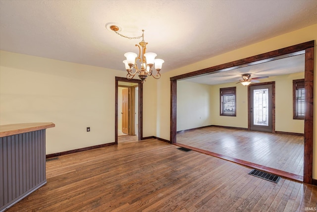 unfurnished dining area featuring dark wood-style flooring, visible vents, and baseboards