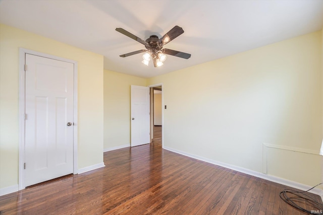 unfurnished bedroom featuring dark wood-style floors, baseboards, and a ceiling fan