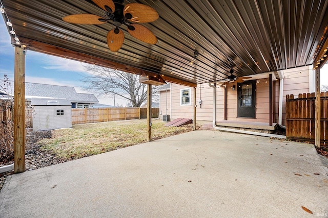 view of patio with a fenced backyard, an outdoor structure, and a storage unit