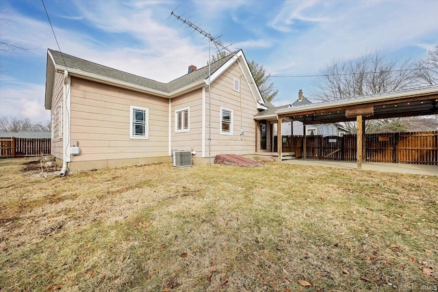 rear view of property featuring a lawn, a patio, a chimney, fence, and cooling unit