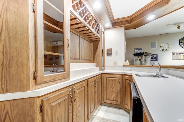 kitchen featuring ornamental molding, light countertops, a sink, and dishwasher