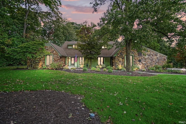 view of front of home featuring stone siding and a front lawn