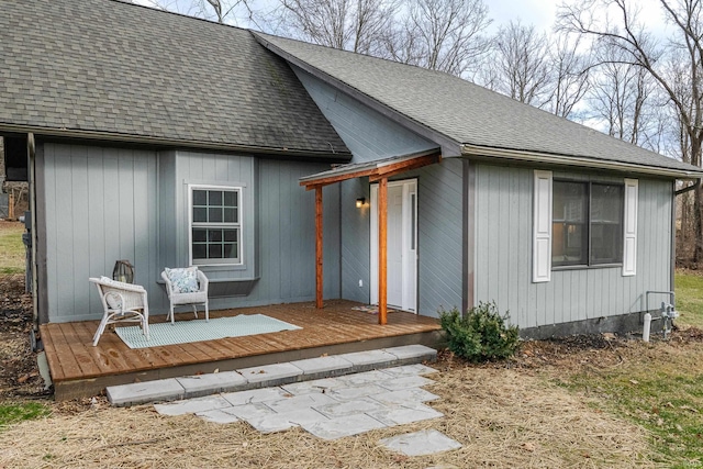 rear view of property featuring a wooden deck and roof with shingles