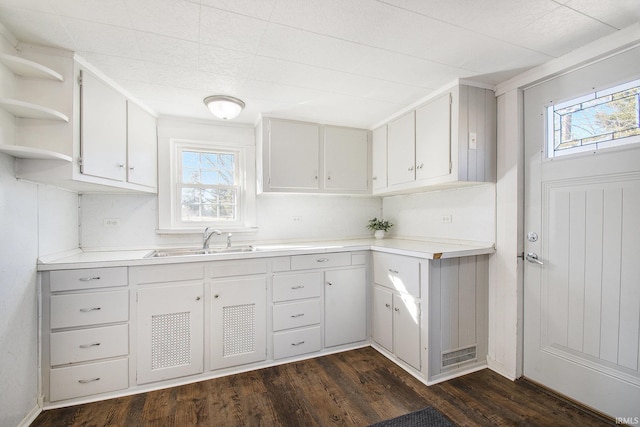 kitchen featuring light countertops, a sink, a wealth of natural light, and white cabinets