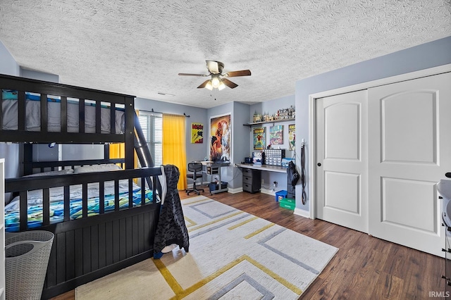 bedroom featuring ceiling fan, a textured ceiling, baseboards, and dark wood-style flooring