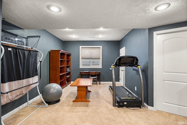 exercise area featuring a textured ceiling, carpet flooring, and baseboards