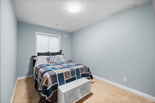 bedroom featuring carpet, visible vents, baseboards, and a textured ceiling