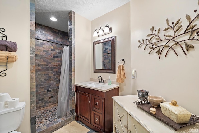 bathroom featuring toilet, a shower stall, a textured ceiling, and vanity