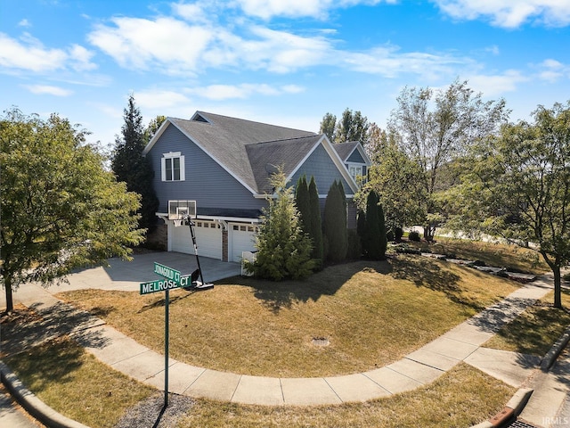 view of front facade with a garage, a front yard, and concrete driveway