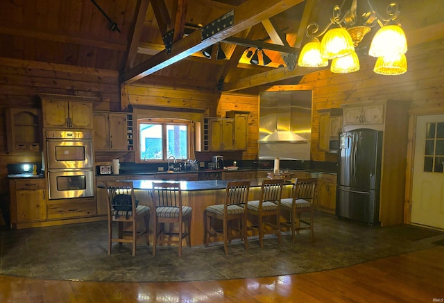 kitchen with stainless steel appliances, dark wood-type flooring, wood walls, range hood, and dark countertops