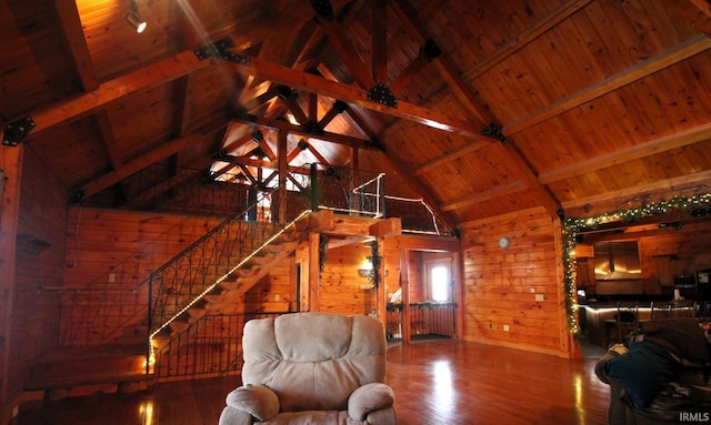 unfurnished living room featuring lofted ceiling with beams, wood walls, wood ceiling, and wood finished floors