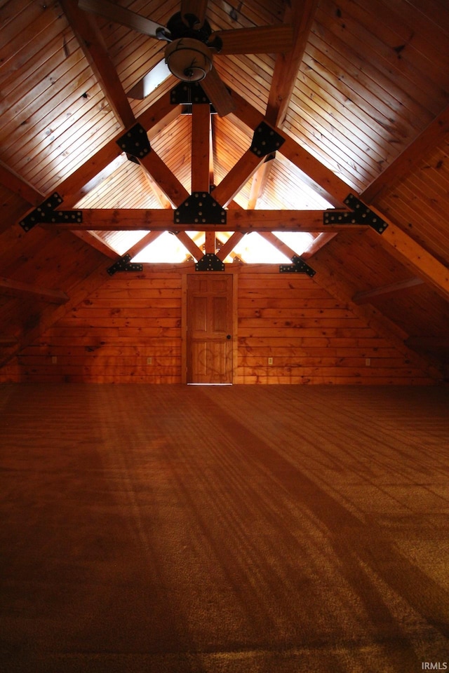 bonus room featuring carpet, vaulted ceiling with beams, and wooden walls