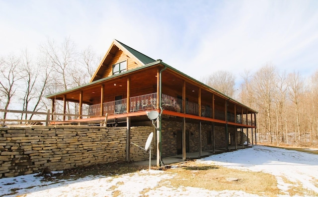 view of snow covered exterior featuring stone siding