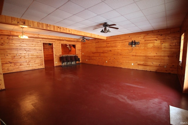 below grade area with ceiling fan and wooden walls