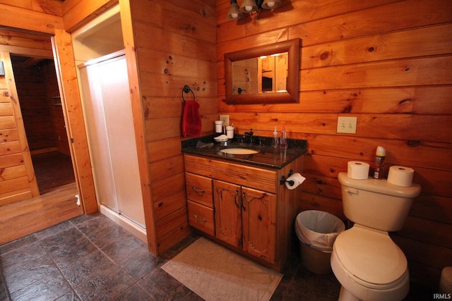 full bath featuring wooden walls, toilet, a shower stall, and vanity